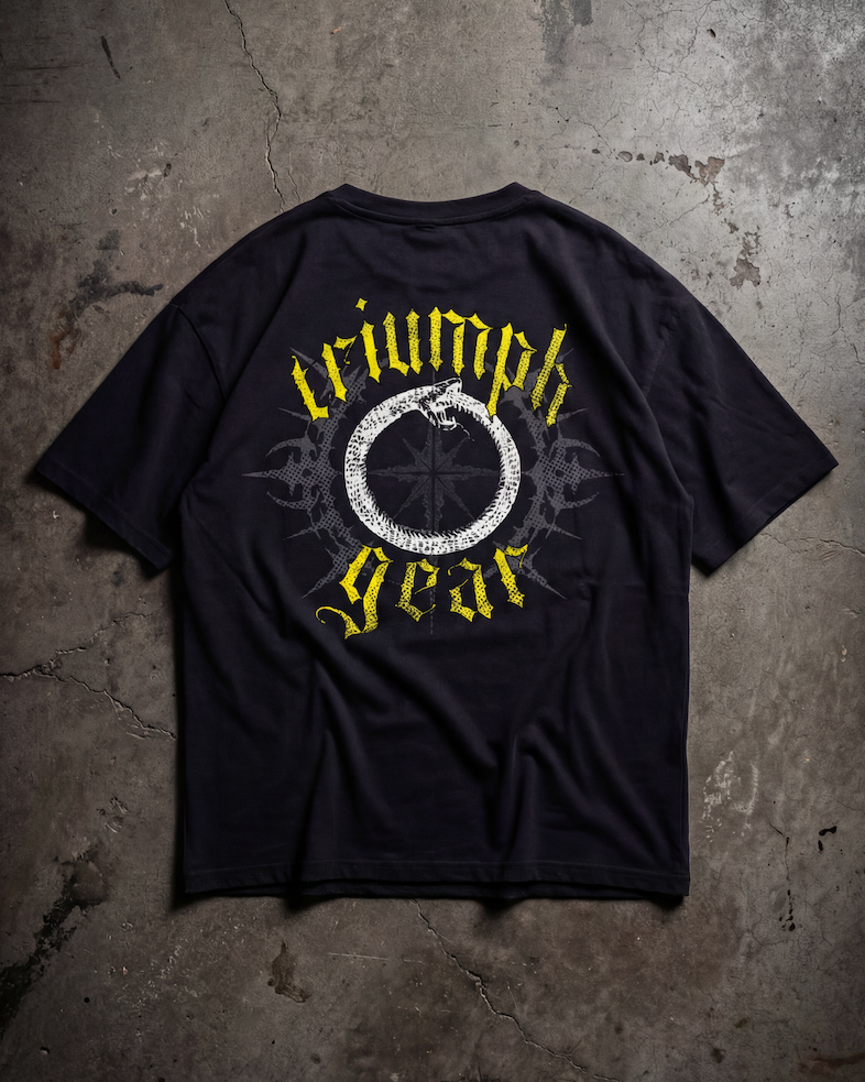 Black t-shirt with 'triumph gear' logo on a textured gray surface