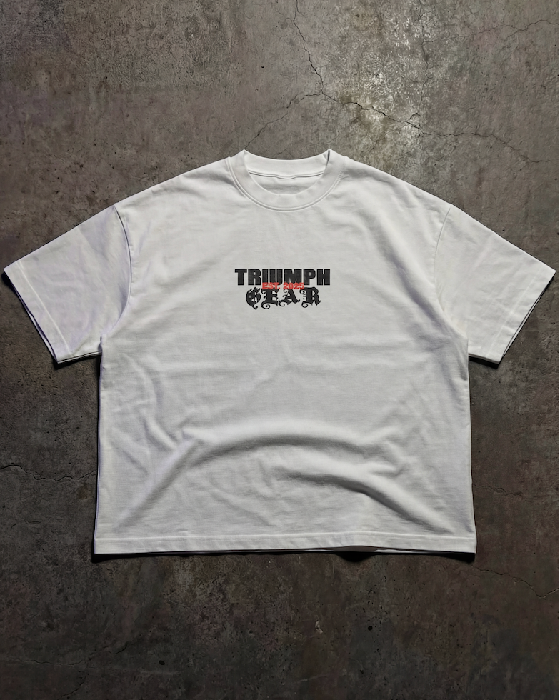 White t-shirt with 'Triumph' logo on a dark textured surface