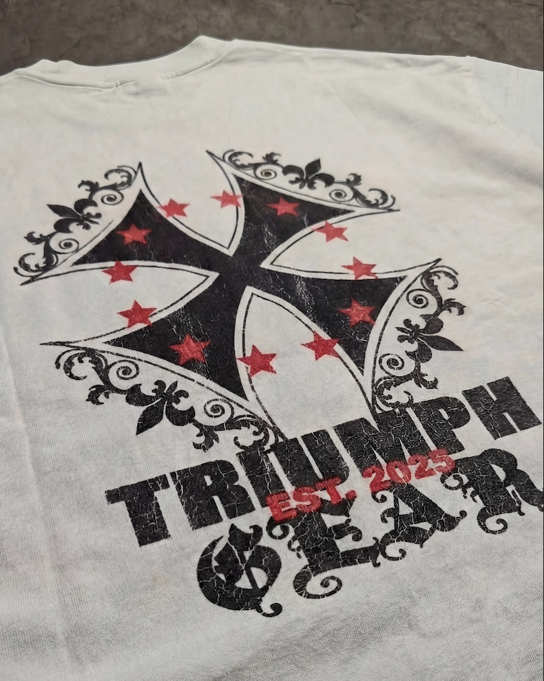 White t-shirt with black and red graphic design on a gray surface