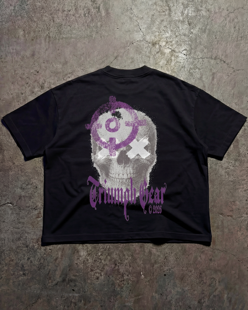 Black t-shirt with a skull design and text on the back, displayed on a textured surface.